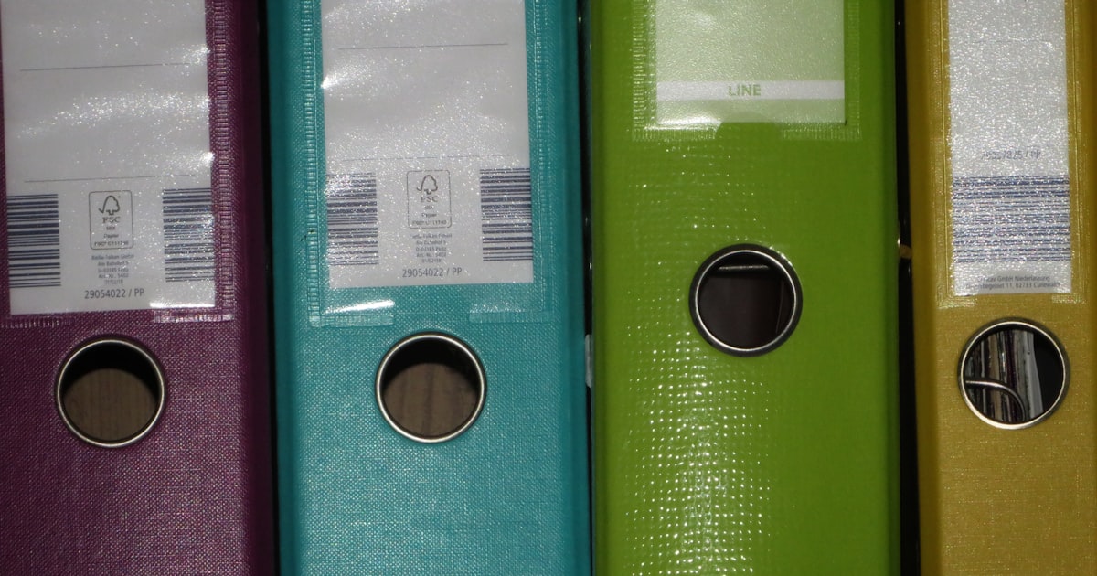 A row of colored binders on a shelf