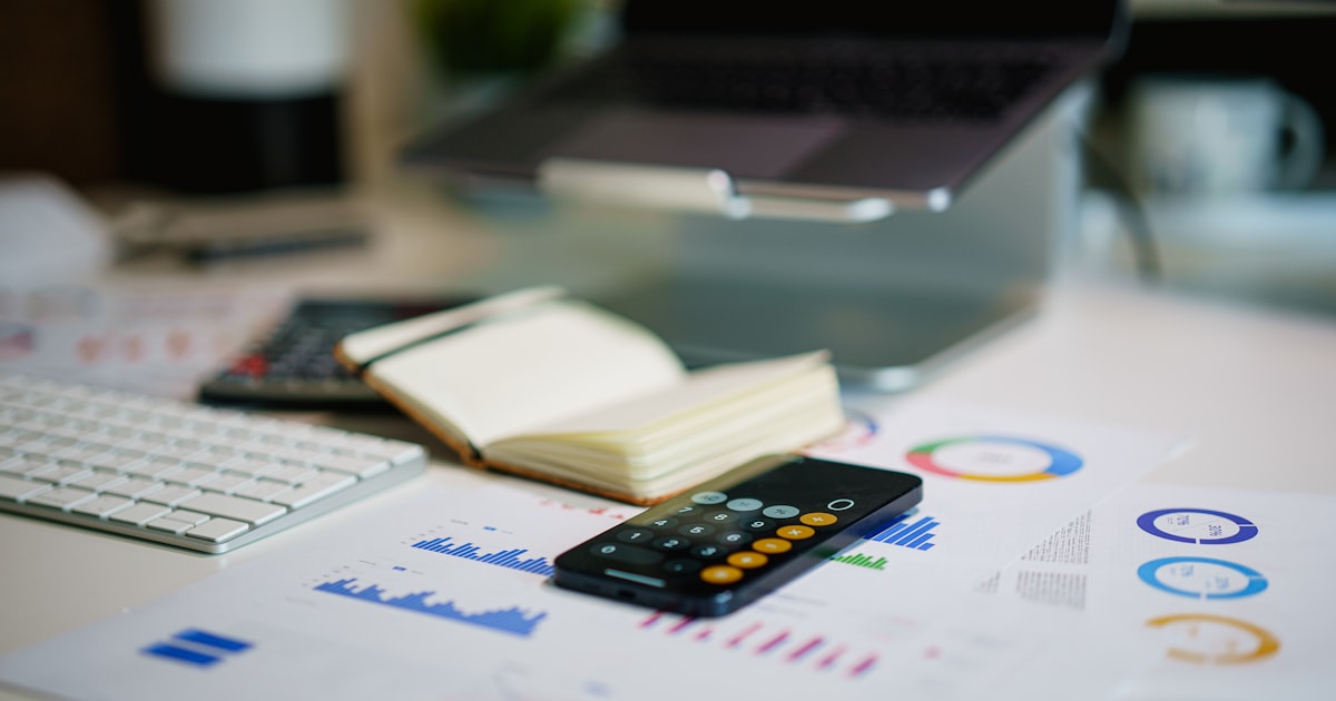 Office desk with smartphone and financial charts